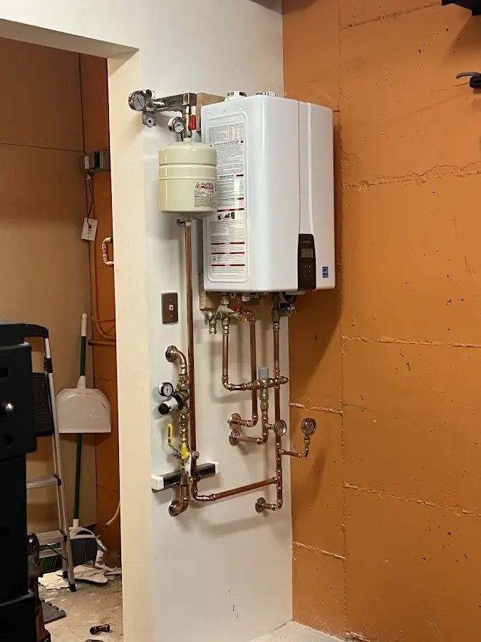 Plumbing technician inspecting water heater connections in Weehawken